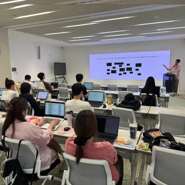 슈퍼플래닝 강사가 화면기획 사례를 설명하고 참석자들이 노트북으로 문서를 작성하는 UX기획 강의 현장